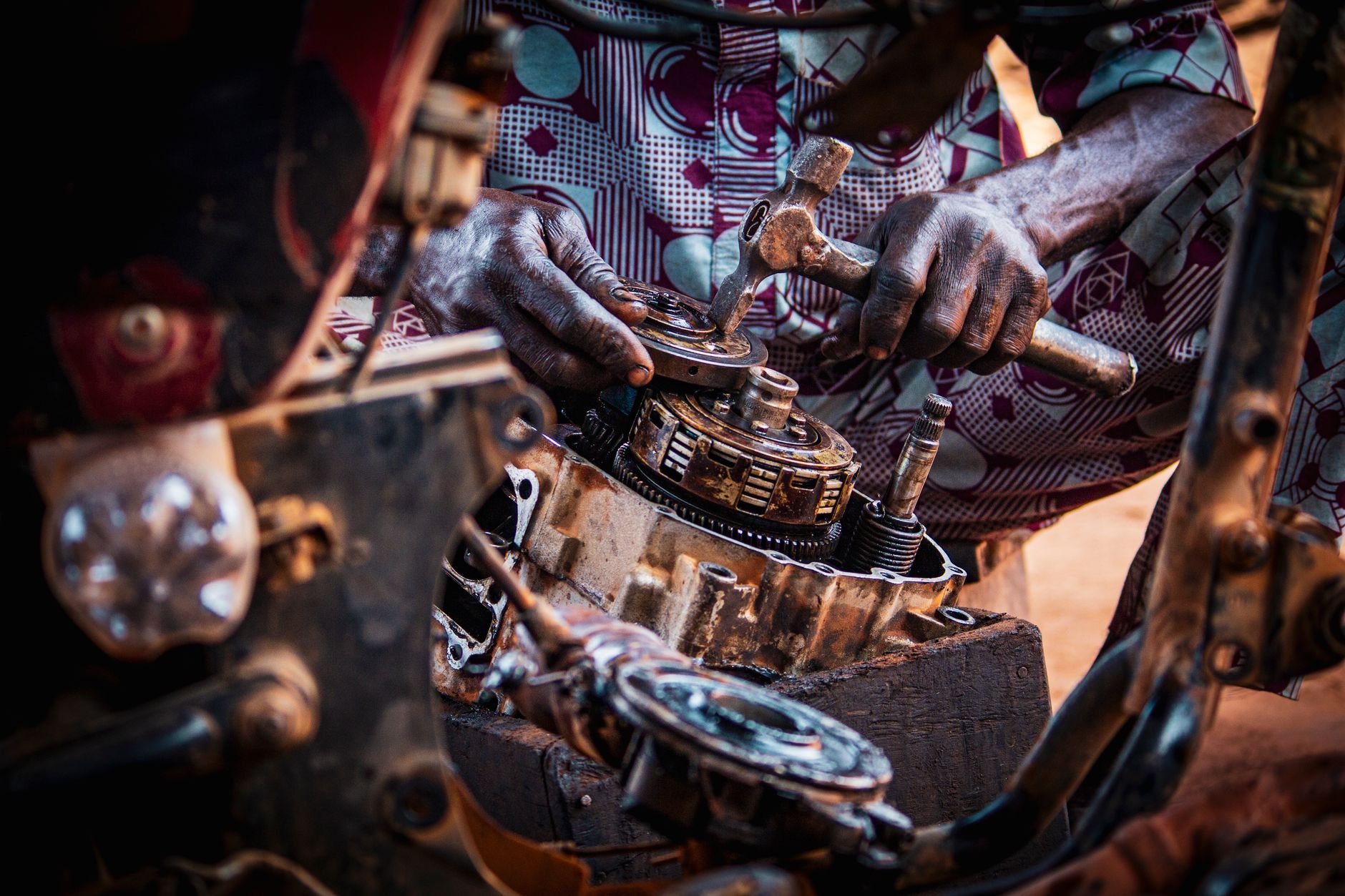 Mechanic focused on assembling motorcycle engine parts in a workshop.